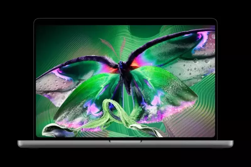 Otvoren Apple MacBook Pro sa šarenim leptirom na PROLED XDR OLED ekranu