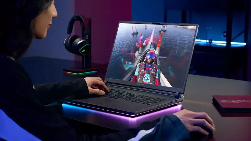ASUS ROG Strix laptop sa RGB osvetljenjem na sivom stolu tokom igranja.