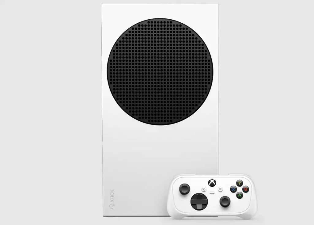 Beli Xbox Nano kontroler u prvom planu, sa Xbox konzolom iza njega.